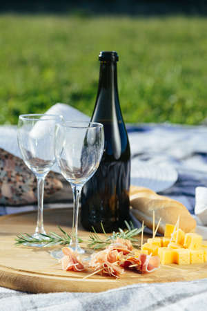 2 glasses of red wine with bread and cheese, pierced on a wooden tray.の写真素材