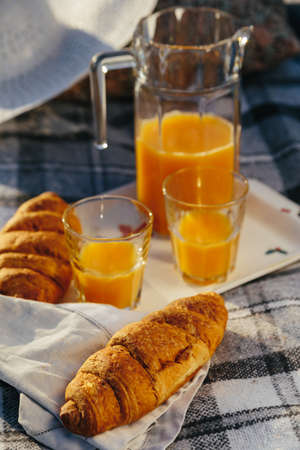 Tasty continental breakfast with fresh puff croissants, orange juice, closeup on croissantsの写真素材