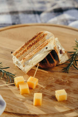 Fresh sandwich with meat and herbs with pieces of cheese and wine in fresh airの写真素材