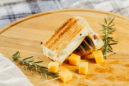 Fresh sandwich with meat and herbs with pieces of cheese and wine in fresh airの写真素材