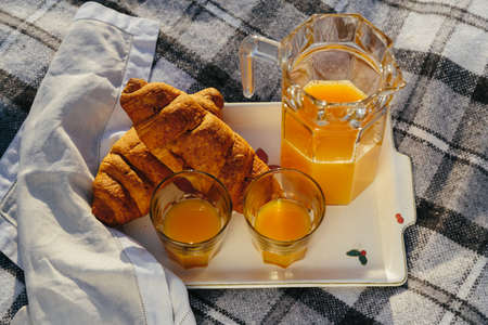 Tasty continental breakfast with fresh puff croissants, orange juice, closeup on croissantsの写真素材