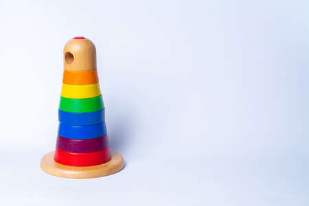 wooden pyramid tower of rainbow blocks stacked on top of each other, on a white background with space for text on the right side of the photo. object placed on the left. horizontal photo orientationの写真素材