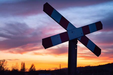 Saint Andrew's cross at the railroad crossing at sunsetの写真素材
