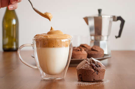 Korean coffee (dalgona caffee) and chocolate muffin on the tableの写真素材