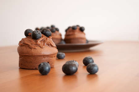 Chocolate muffin with blueberries on woodの写真素材