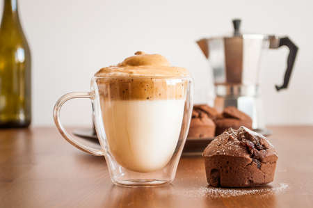 Korean coffee (dalgona caffee) and chocolate muffin on the tableの写真素材