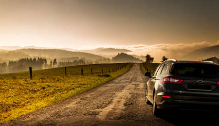 Hanu?ovice, Czech Republic - 10.27.2019 A car parked on a dirt road leading to the horizon. Picture taken in the Czech Republic in the mountain region.のeditorial素材