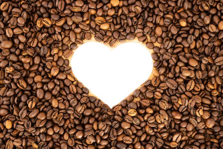 Heart formed by coffee beans on woodの写真素材