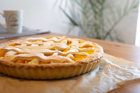 Peach tart lies on the table.の写真素材