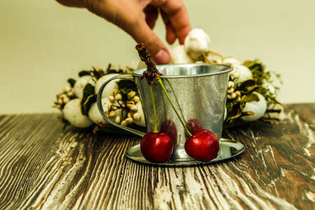 Cherries in a bucket on wooden backgroundの写真素材