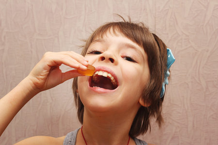 Girl about to eat a tasty piece of candy.の写真素材