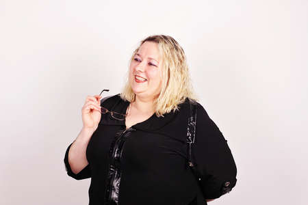 Very complete cheerful woman in a black dress with glasses in hand.の写真素材