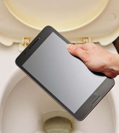 A woman without regret throwing the toilet smartphone.の写真素材