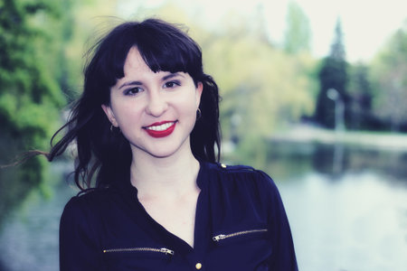 Happy smiling young girl in a city park in the spring afternoon.の写真素材