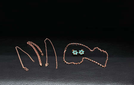 Womens gold jewelry chain, bracelets, earrings isolated black background.の写真素材