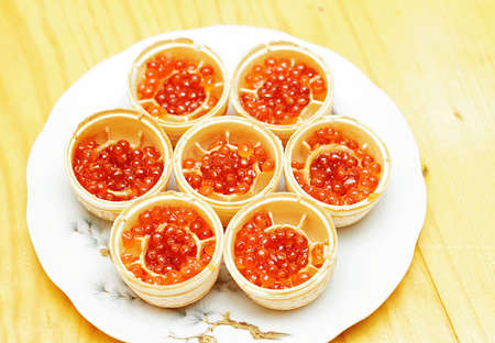 Waffle tartlets with caviar of salmon fish on a kitchen plate.の写真素材