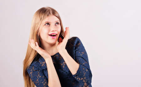 Cute blonde girl shows her surprise. Studio photo.の写真素材