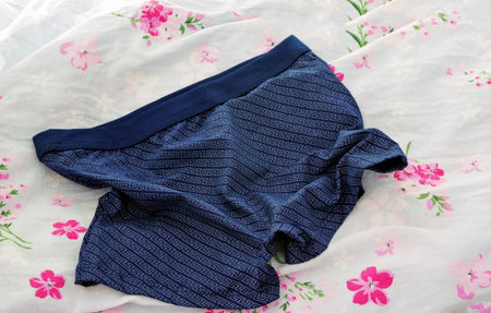A little wrinkled men's boxers on the bed linen.