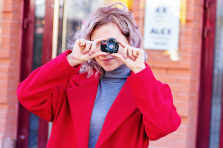 The girl seems to be taking pictures with a dummy compact camera.