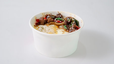 Stir fried pork with chili sauce in white bowl on white backgroundの写真素材