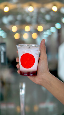 Strawberry cocktail in hand on bokeh backgroundの写真素材