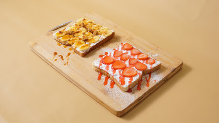 waffle with strawberry and cream on wood plate isolate on brown backgroundの写真素材