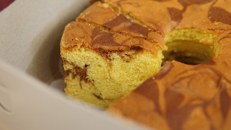 pieces of sponge cake with a chocolate pattern in an open package displayed in the shop windowの写真素材