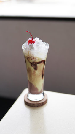 avocado juice with whipped cream and cherry in a glass on tableの写真素材