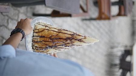 Woman eating a crepe cake in a cafe. Close-upの写真素材