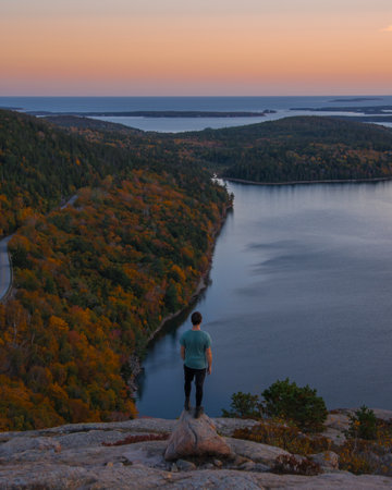 Epic Sunrise Landscape Male Hiker in Green Shirt Stands On Rock Edge. Acadia National Park Adventure Inspiring Nature Photography South Bubble Trailの写真素材
