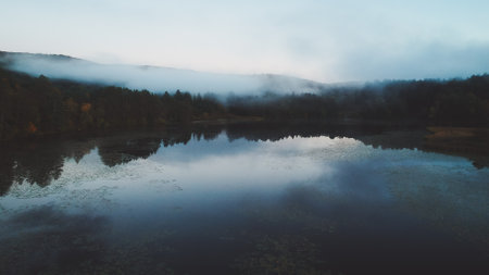 Calm Mirror Lake in Upstate Vermont with Low Hanging Clouds. Nature Landscape Serene Background Blue Hour Close to Sunset Natureの写真素材