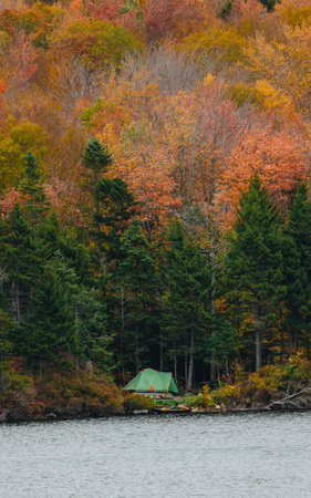Green Tent Camping Side of Lake Autumn in Green Mountains Vermont. Fall Foliage Colorful Trees Canoe On Shore Next to Campsiteの写真素材