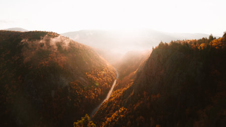 Epic Autumn Table Rock New Hampshire Sunrise Fall Foliage View From Top. Road in Distance Sun Flare. Warm Light Nature Scene.の写真素材