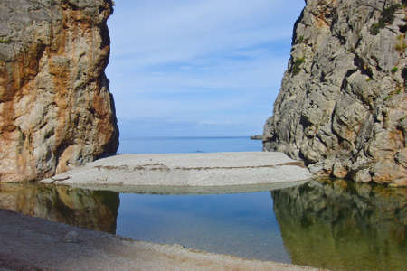 small island with a gateway to the sea from cliffsの写真素材