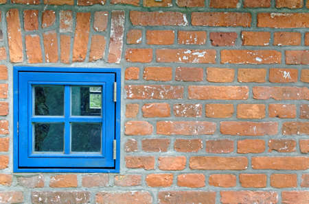 blue window at an old brickの写真素材