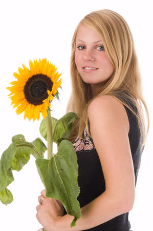 The attractive blonde in studio holds a sunflower in handsの写真素材