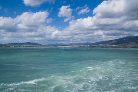 A sea landscape with a kind on a bay of seaside small town.の写真素材
