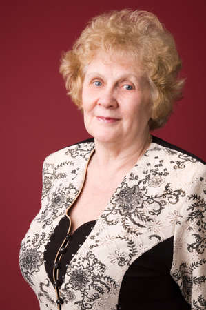 The cheerful elderly woman on a grey background.の写真素材