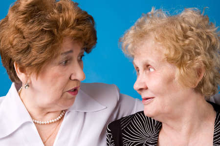 A portrait of two cheerful elderly women on a dark blue background.の写真素材