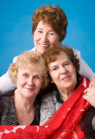 A portrait of three cheerful elderly women on a dark blue background.の写真素材