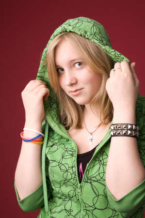 The young girl in green clothes on a red background.の写真素材