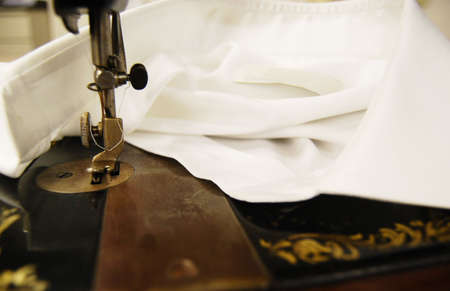 Old sewing machine on a white shirtの写真素材