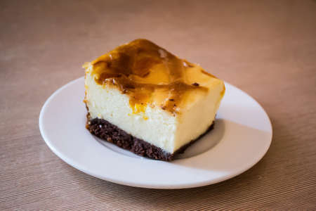 Cheesecake on a plate on a wood table.の写真素材
