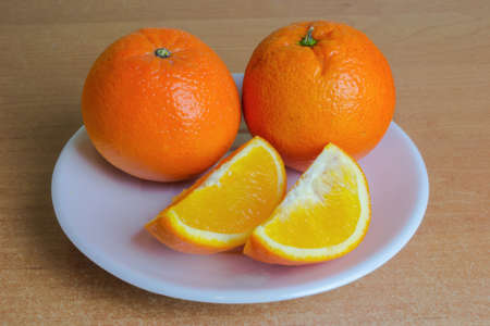 Orange fruits on the plate on the table.の写真素材