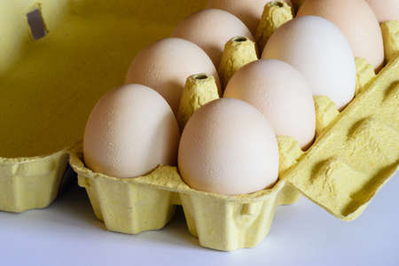 Eggs in the carton box on the white background.の写真素材
