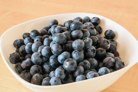 Fresh Polish blueberries in a bowl on a wooden table.の写真素材