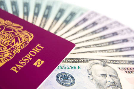UK Passport holding a fan of US Dollarsの写真素材
