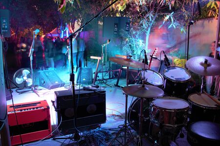 Drum set and guitar amps looking out on stage and into the audience at a small gigの写真素材