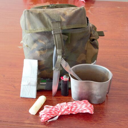 Survival pouch with tin cup, knife, paracord, tape, candle, flint and steel and lighterの写真素材
