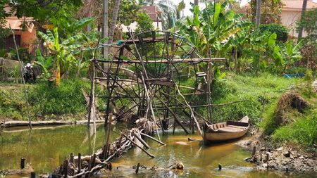water pump wheel and boat in river in cambodia siem reap asiaの写真素材